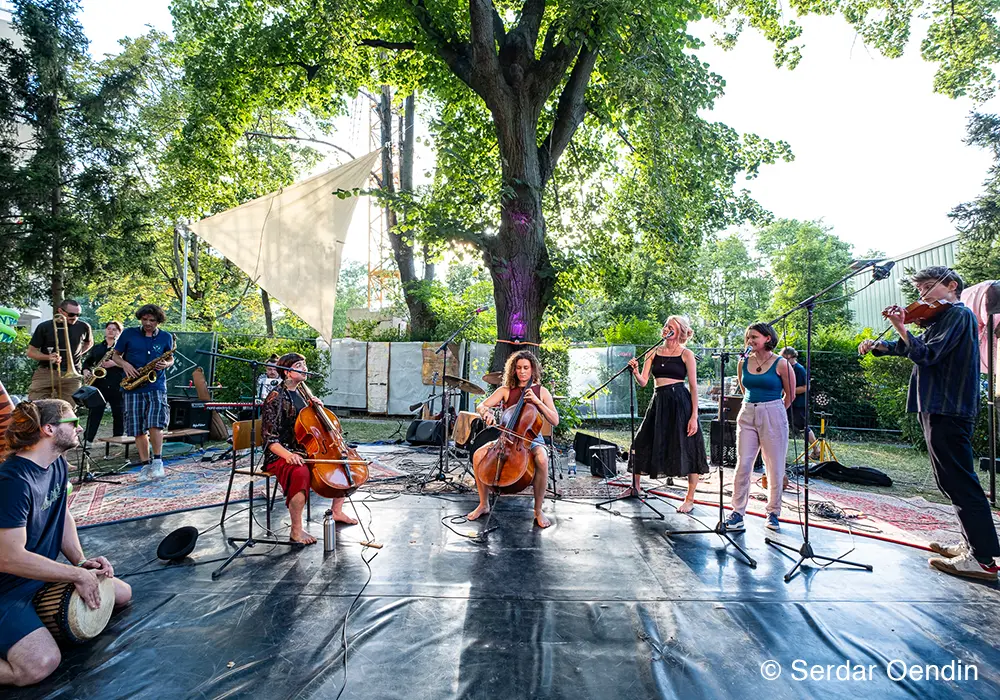 Several young artists playing on a stage with with cello, violin, singing and other instruments